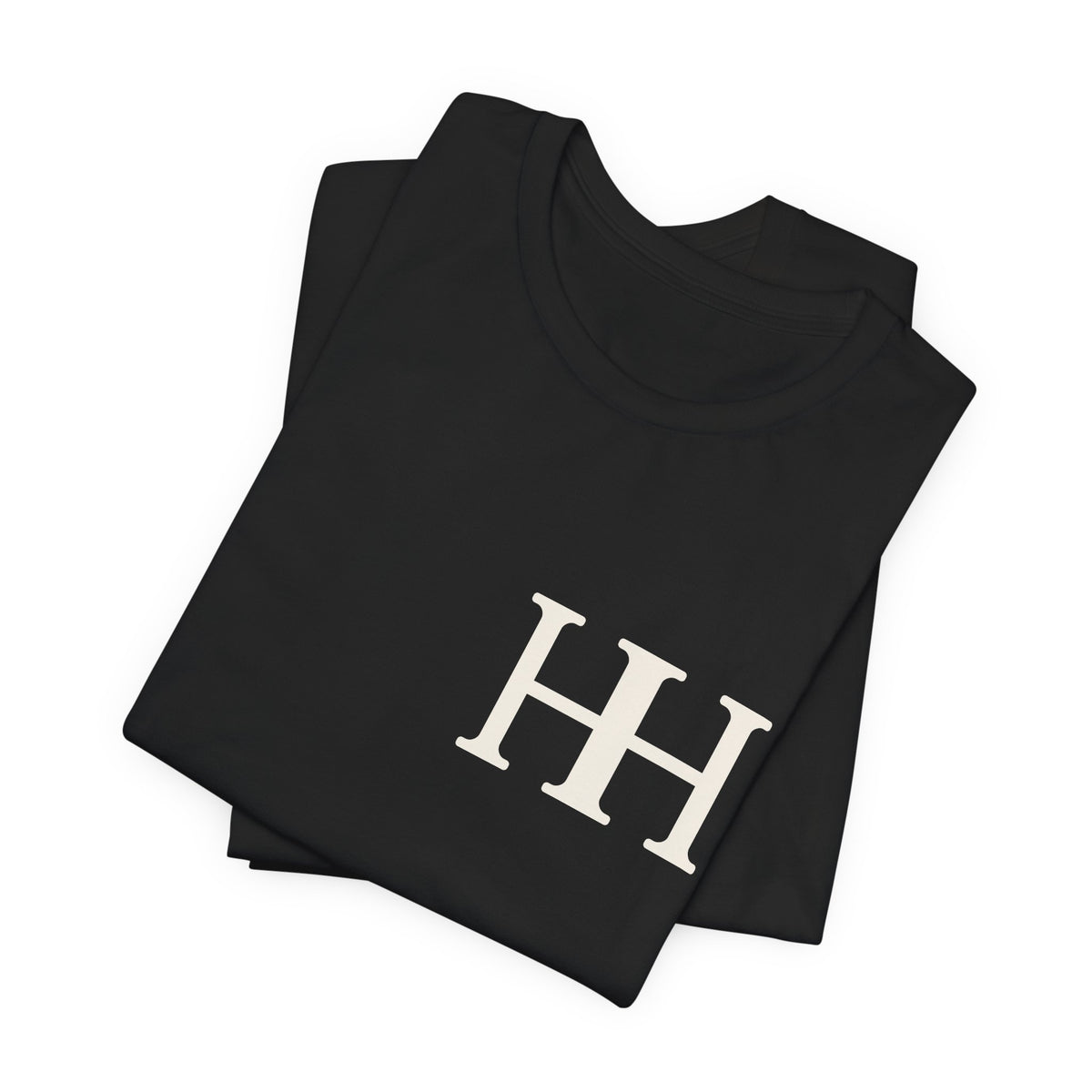 Mockup: black Soft tee folded, showing the ivory HH mark
