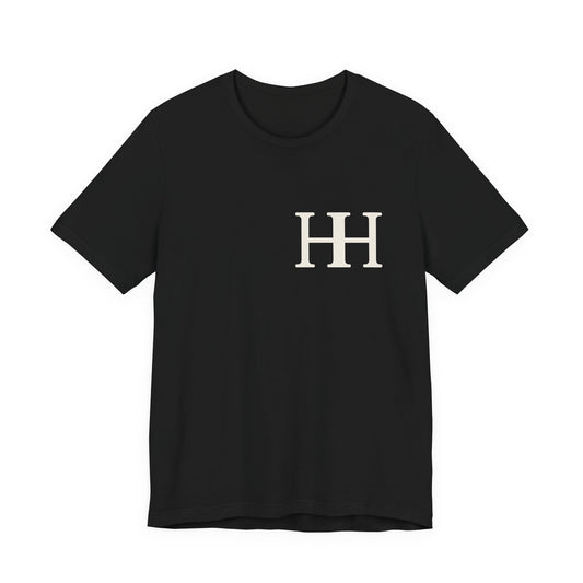 Mockup: front of the black Soft tee (Bella+Canvas 3001) with the ivory HH mark on the left chest