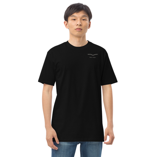 Person wearing the black love stays. The Held Line Tee, front view with a small cream line and love stays. on the left chest