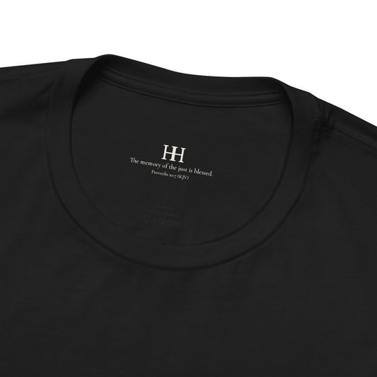 Collar close-up of the black tee: a small cream HH monogram over the verse The memory of the just is blessed, Proverbs 10:7 (KJV). Print mockup.