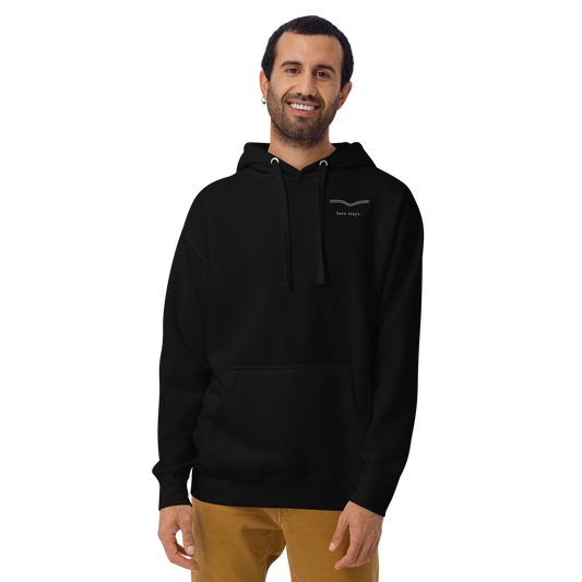Person wearing the black love stays. The Held Line Hoodie, front view with a small cream line and love stays. on the left chest